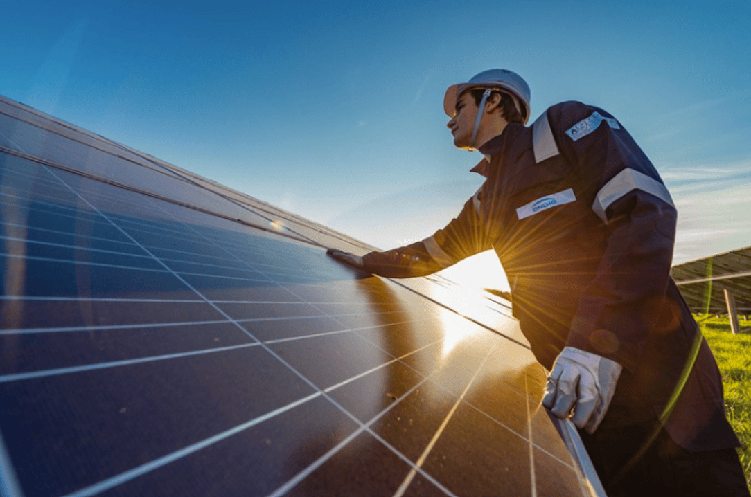Solar energy technician inspecting solar panels for renewable energy production.